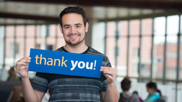 UWEC student Brendon Hernandez holds Thank You sign