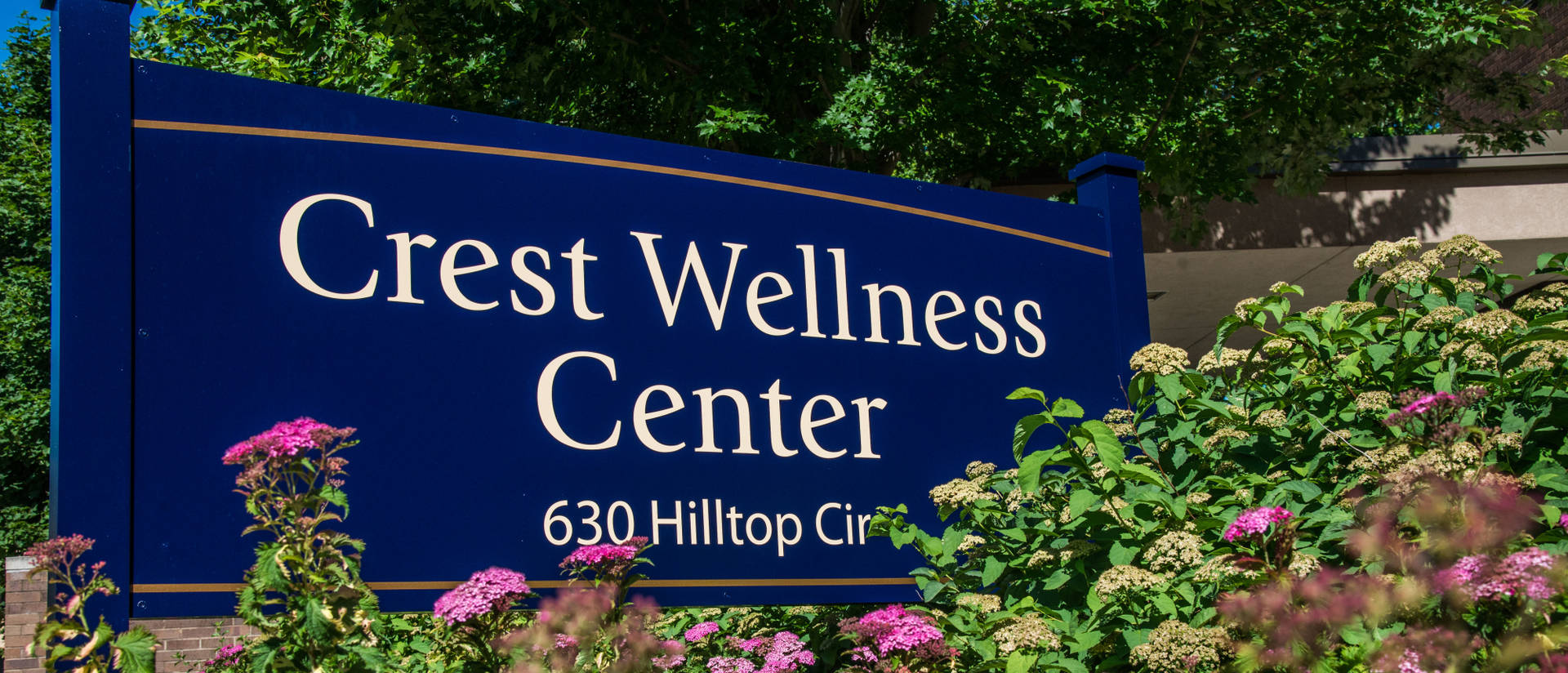 Crest Wellness Center sign surrounded by flowers
